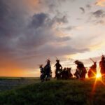 Indigenous community members standing together at sunset in Alberta, symbolizing culturally grounded mental health support and healing.