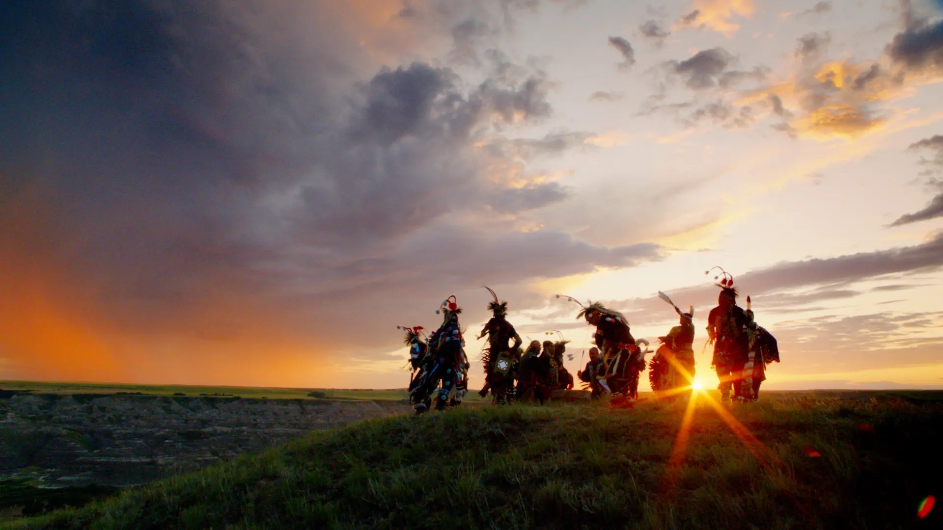 Indigenous community members standing together at sunset in Alberta, symbolizing culturally grounded mental health support and healing.