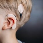 Child wearing a cochlear implant, highlighting hearing innovation supported by Canadian charities in Manitoba