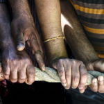 Diverse hands gripping a rope together, symbolizing teamwork and community support within an Alberta addiction recovery charity program.