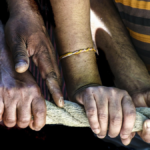 men of different races hands holding rope.