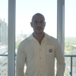 James Milonas, known as "James In The City," stands in front of the Toronto skyline.