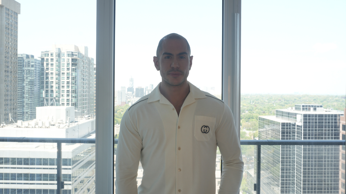James Milonas, known as "James In The City," stands in front of the Toronto skyline.