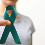 Woman holding a teal ovarian cancer awareness ribbon representing ovarian cancer advocacy and treatment access in Canada