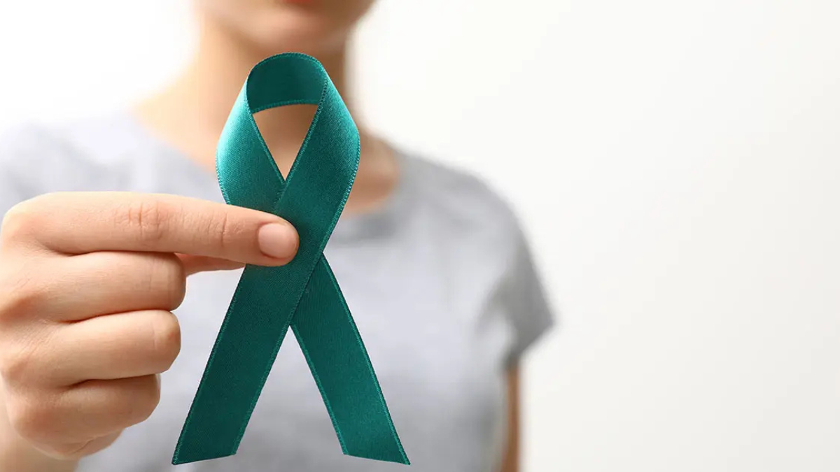 Woman holding a teal ovarian cancer awareness ribbon representing ovarian cancer advocacy and treatment access in Canada
