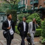Three Black young professionals walking through an urban courtyard, highlighting youth leadership and career development in Canada.