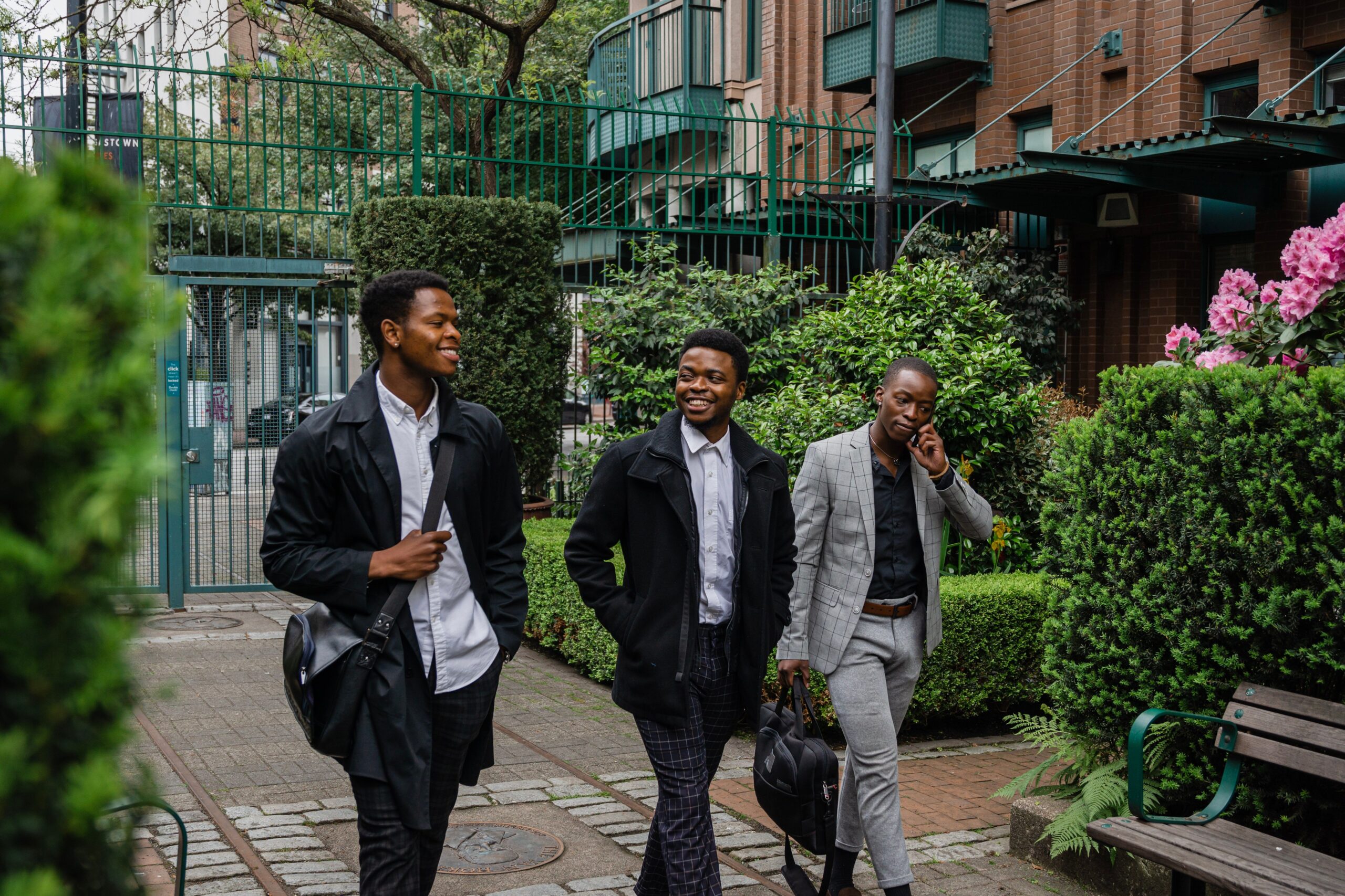 Three Black young professionals walking through an urban courtyard, highlighting youth leadership and career development in Canada.
