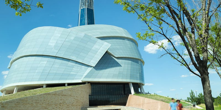 Canadian Museum for Human Rights in Winnipeg, Manitoba, featuring its distinctive architecture under a bright blue sky.