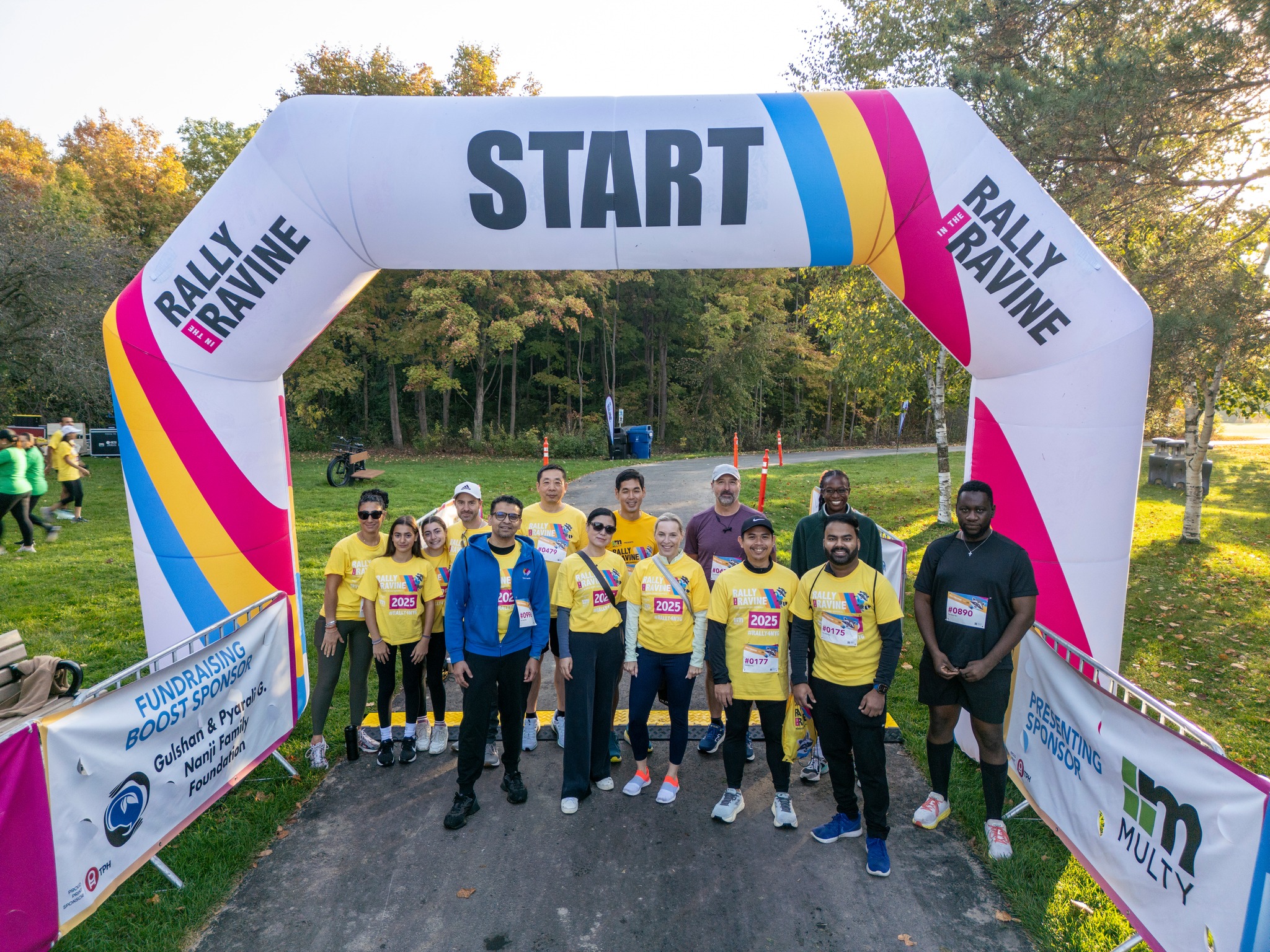 Participants gather beneath the Rally in the Ravine start arch at G Ross Lord Park during North York General Foundation's annual community fundraising walk, run, and roll event.