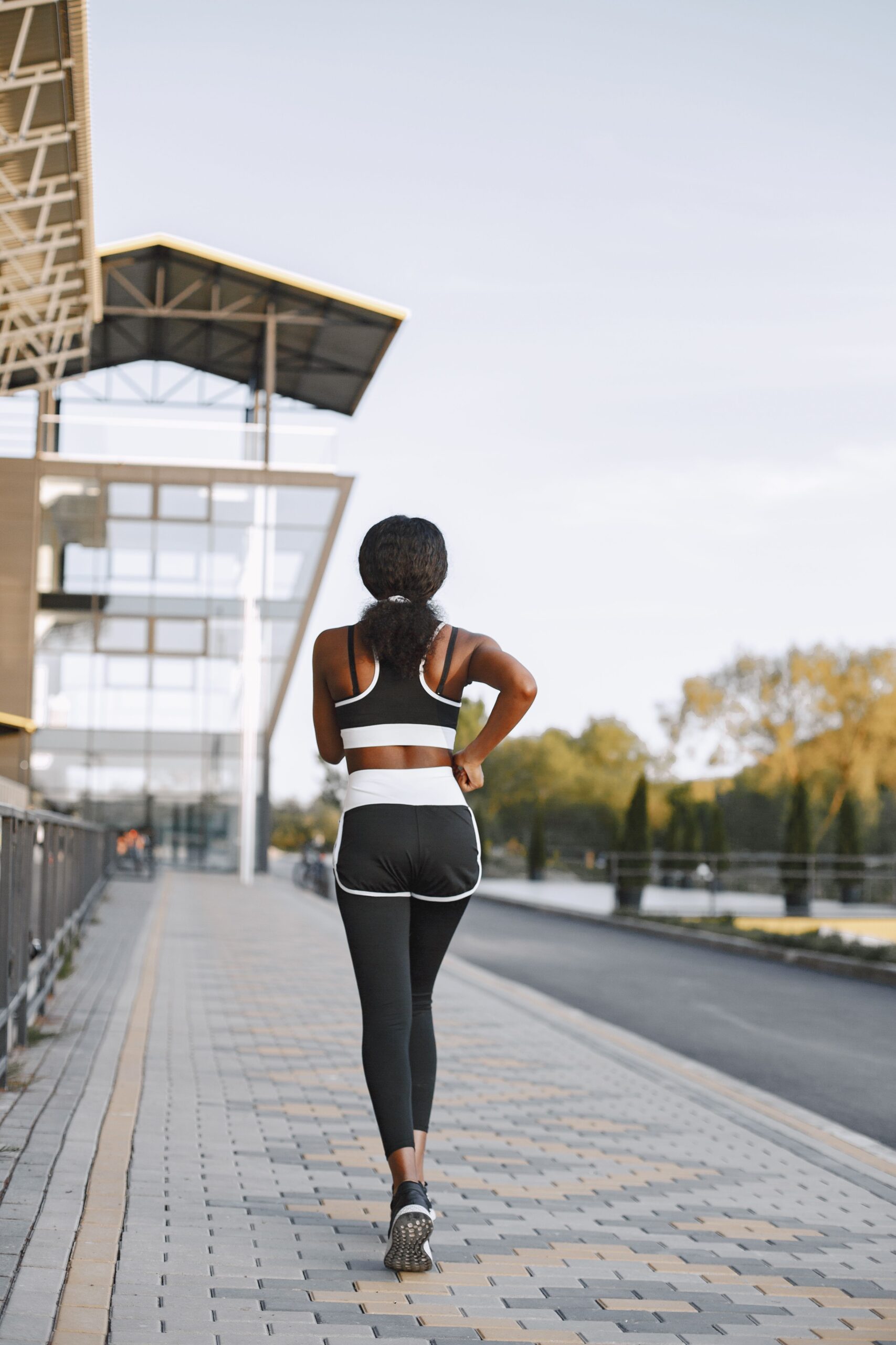 Participant jogging along a paved pathway near a modern building during a community walk and run event.
