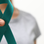 Personne tenant un ruban sarcelle, symbole de sensibilisation au cancer de l'ovaire.